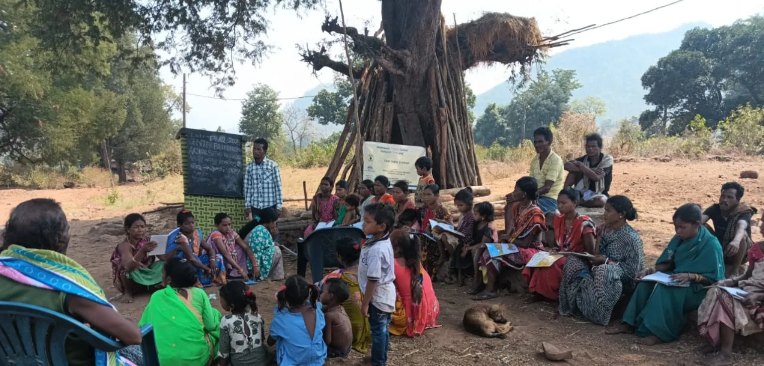 Women and community members participating in an outdoor learning and discussion session.