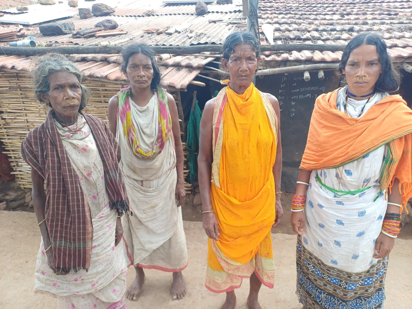 Women from a rural community standing together outside their homes